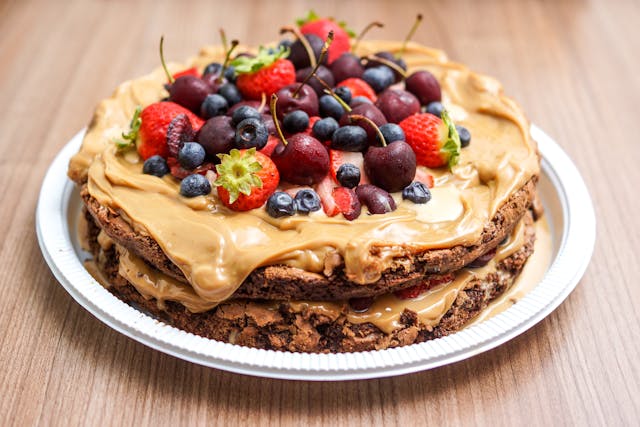 Pancakes covered in peanut butter and assorted fruits